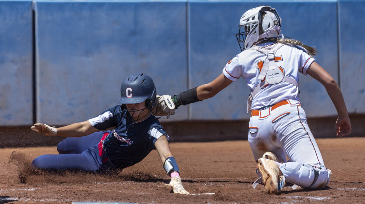 Coronado runner Alohi Mundon (8) attempts a score at home plate over Douglas catcher Peyton Sim ...