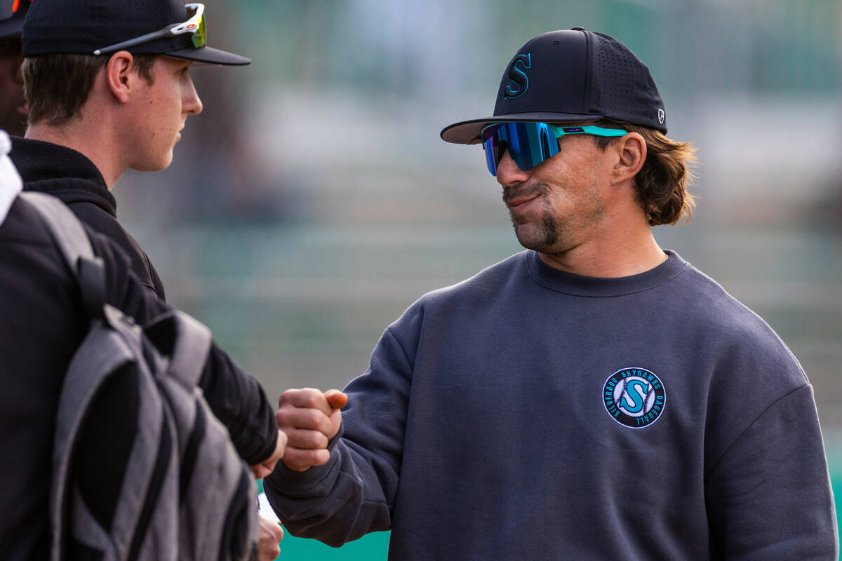 Silverado head coach Jacob Fletcher greets a player near the dugout against Green Valley during ...