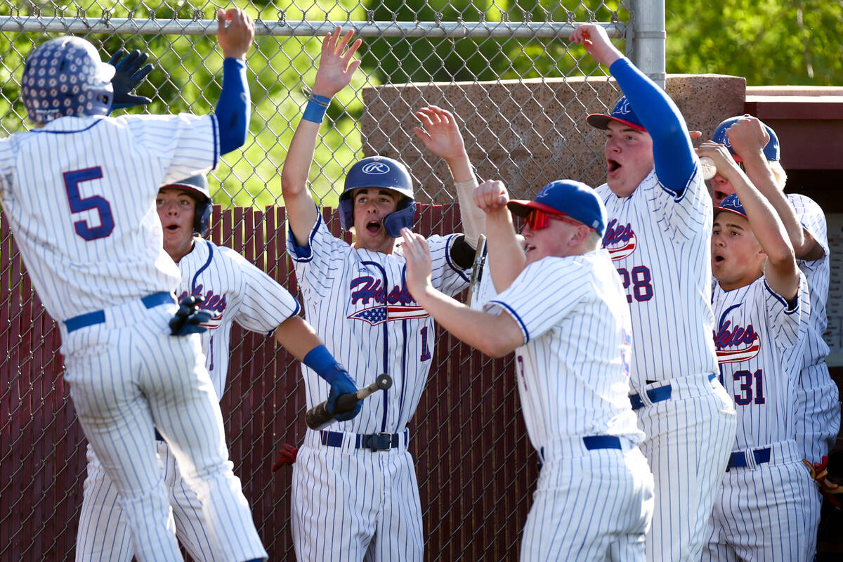 Reno congratulates their Dawson Planeta (5) after he scored during a Class 5A baseball state to ...