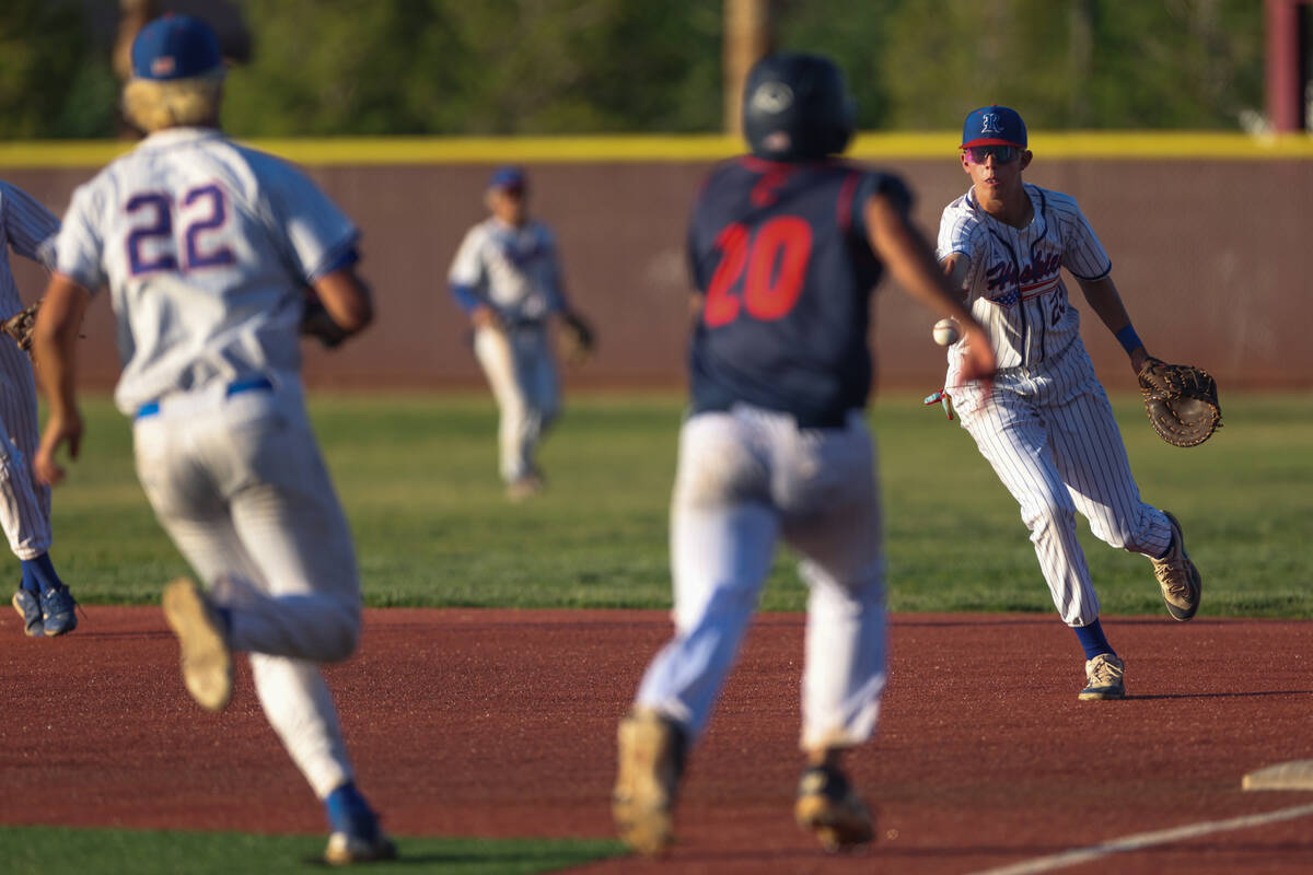 Reno first baseman Luke Sala (23) tosses the ball to pitcher Mack Edwards (22) to get an out on ...