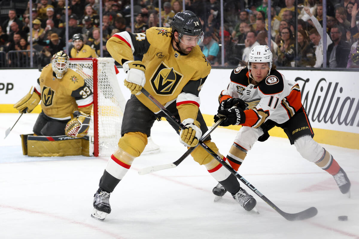 Golden Knights defenseman Nicolas Hague (14) scoops the puck away from Ducks center Trevor Zegr ...