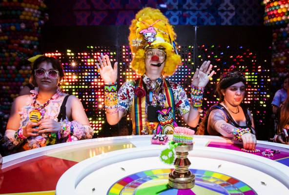 A performer, center, watches as a roulette-style wheel with Kandi bracelets spins during the fi ...