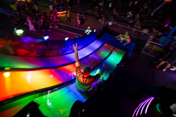 A festival attendee goes down a slide during the second night of the Electric Daisy Carnival at ...