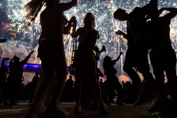 Festival attendees dance as fireworks go off during the third night of the Electric Daisy Carni ...