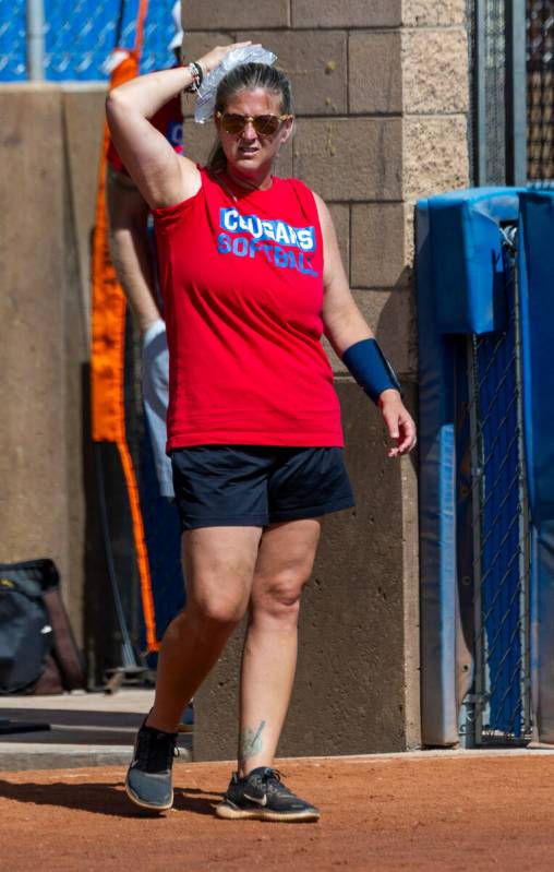 Coronado head coach Lauren Taylor ices her head after being hit by a deflected ball in the dugo ...