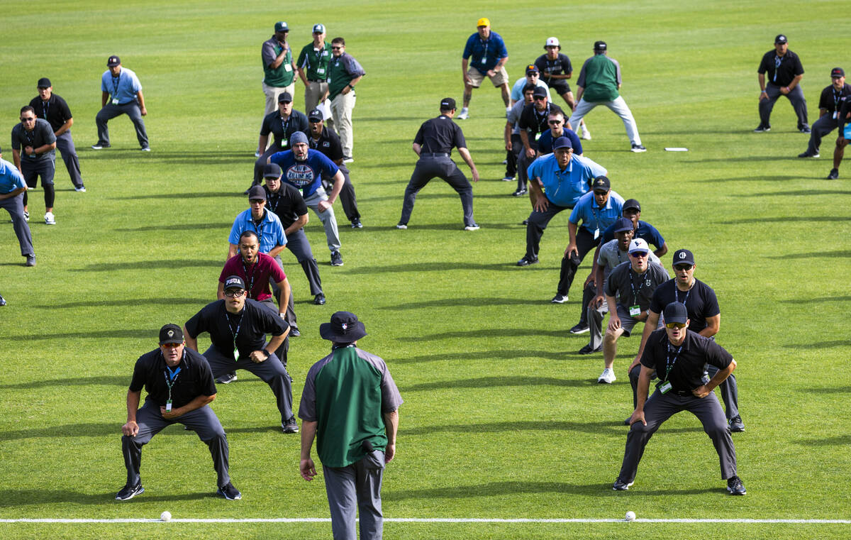 Participants practice their position behind the plate during a Major League camp for umpires at ...
