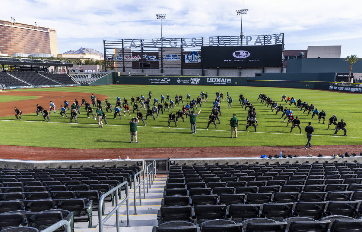 Participants practice their position behind the plate for staff during a Major League camp for ...