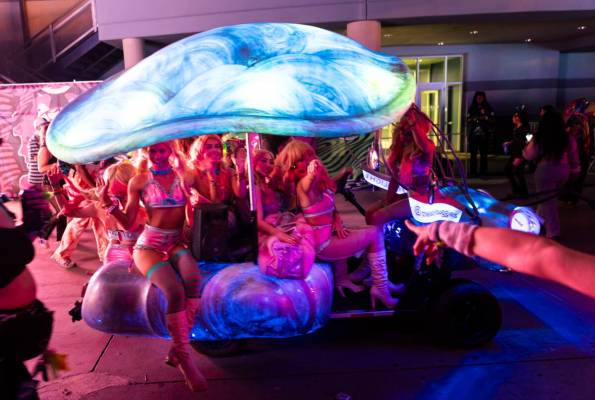 Costumed performers pass by while riding on an art car during the third night of the Electric D ...
