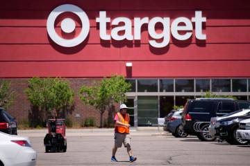 A worker collects shopping carts in the parking lot of a Target store June 9, 2021, in Highland ...