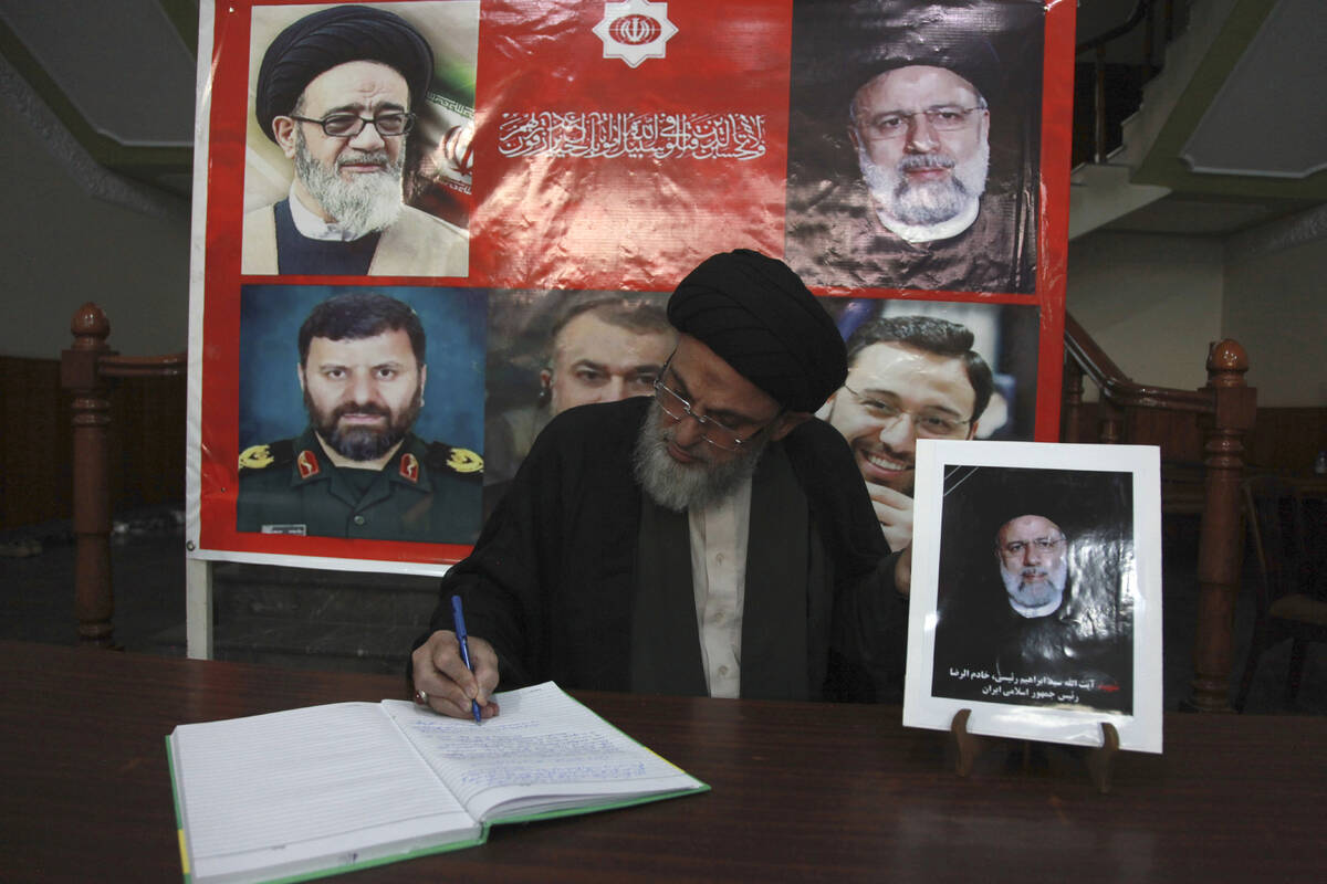 A man writes his comments in a condolence book after attending a ceremony to pay tribute to Ira ...