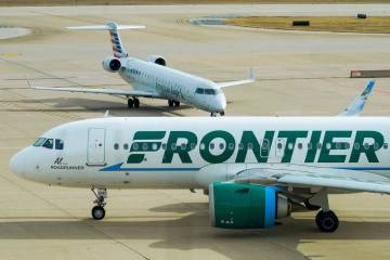 A Frontier Airlines plane taxis past an American Eagle plane near the gates of Terminal E at DF ...