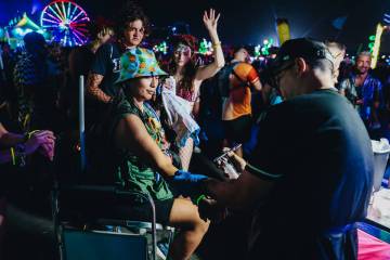 A festival attendee gets an airbrush tattoo of the EDC logo on the third and final night of the ...
