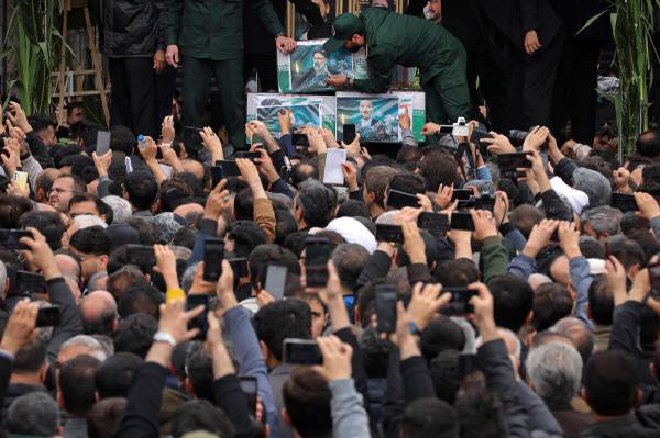 In this photo released by the Iranian Presidency Office, mourners gather around a truck carryin ...