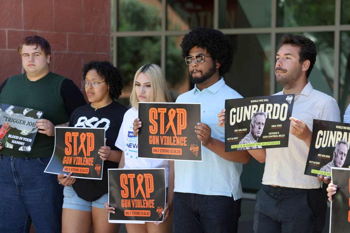 Students hold signs during a press conference demanding action to end gun violence on campus or ...