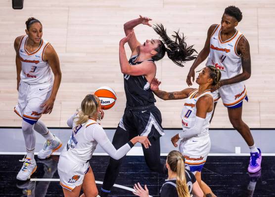 Aces center Megan Gustafson (17) has the ball stripped from behind bye Phoenix Mercury guard Na ...