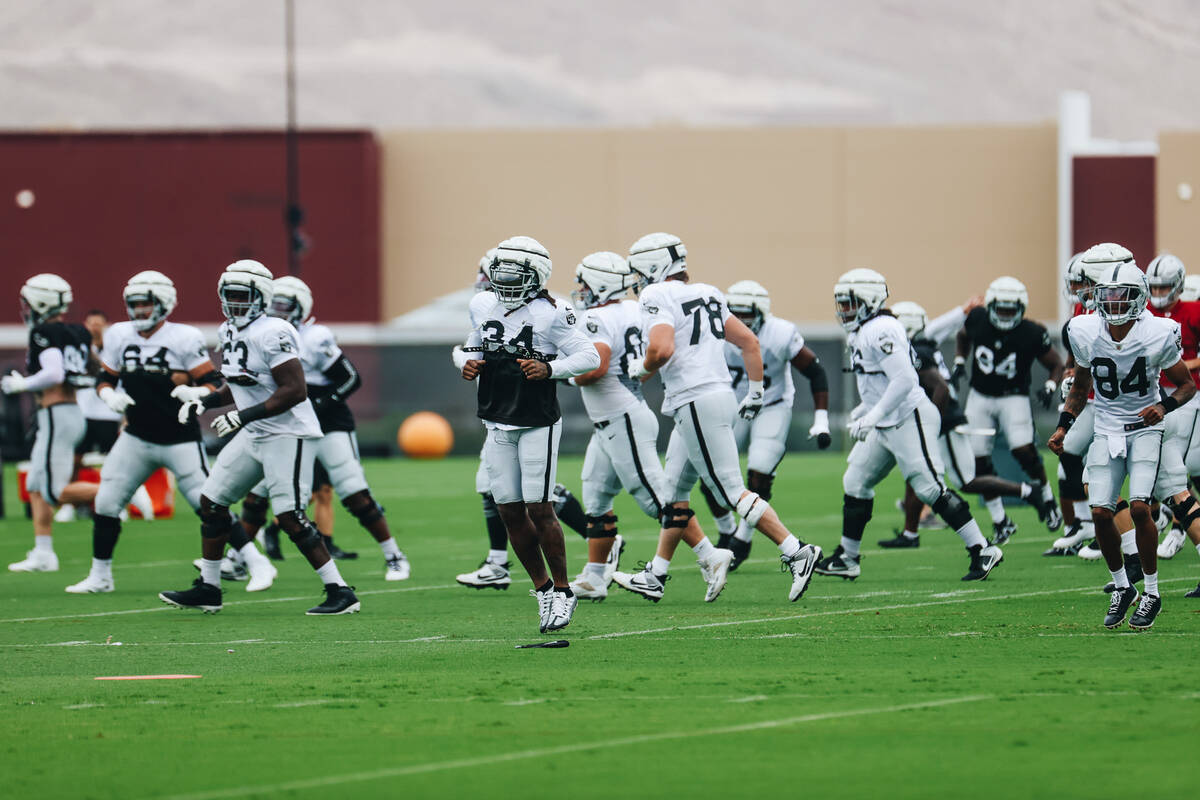 Raiders players warm up during training camp at the Intermountain Health Performance Center on ...