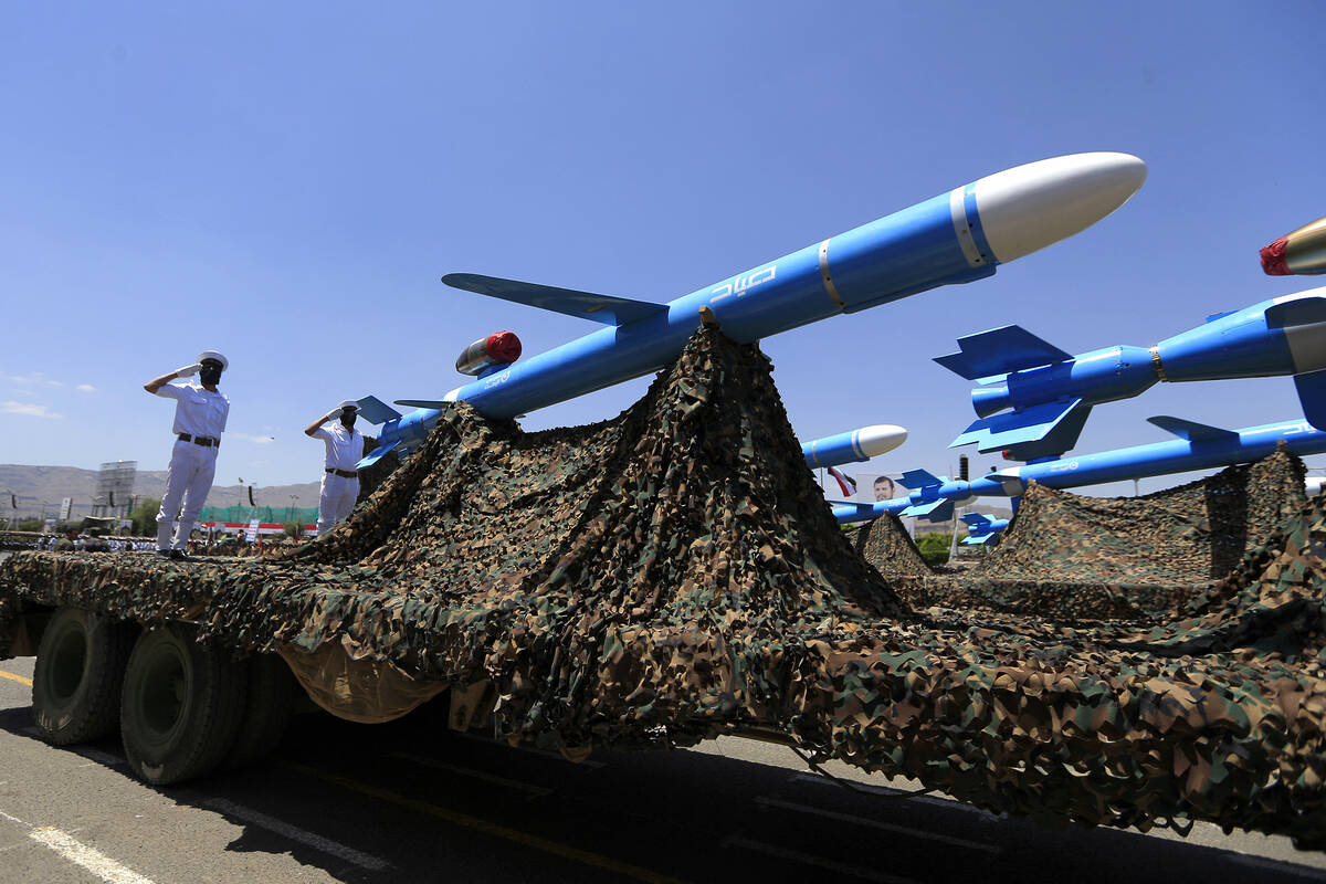 Huthi soldiers stand guard on a missile carrier during an official military parade marking the ...