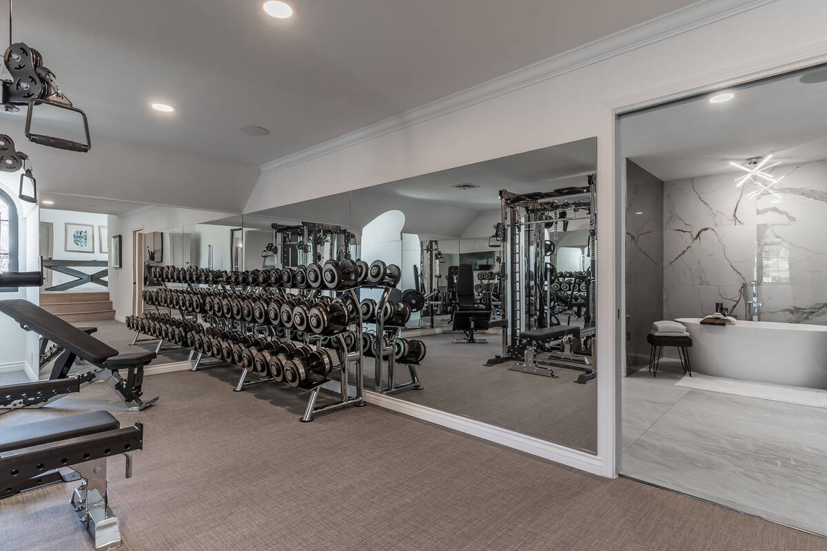 The fitness room features a variety of free-hand weights and exercise machines, including a tre ...