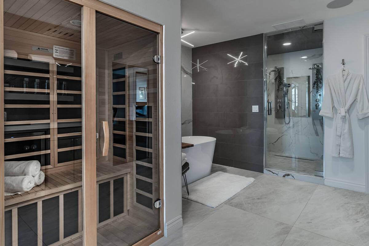 A bath adjacent to the gym showcases luxurious spa amenities, such as a marble steam shower wit ...