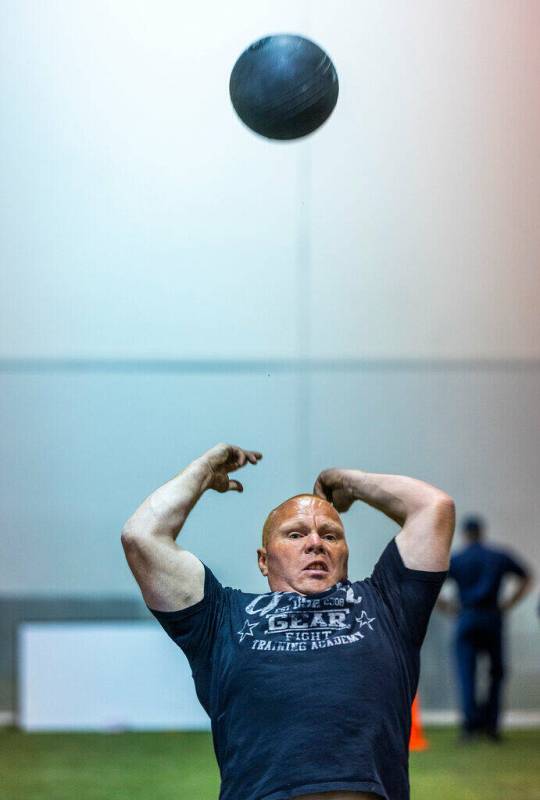 A participant tosses a medicine ball backwards during the Las Vegas Fire & Rescue free comm ...