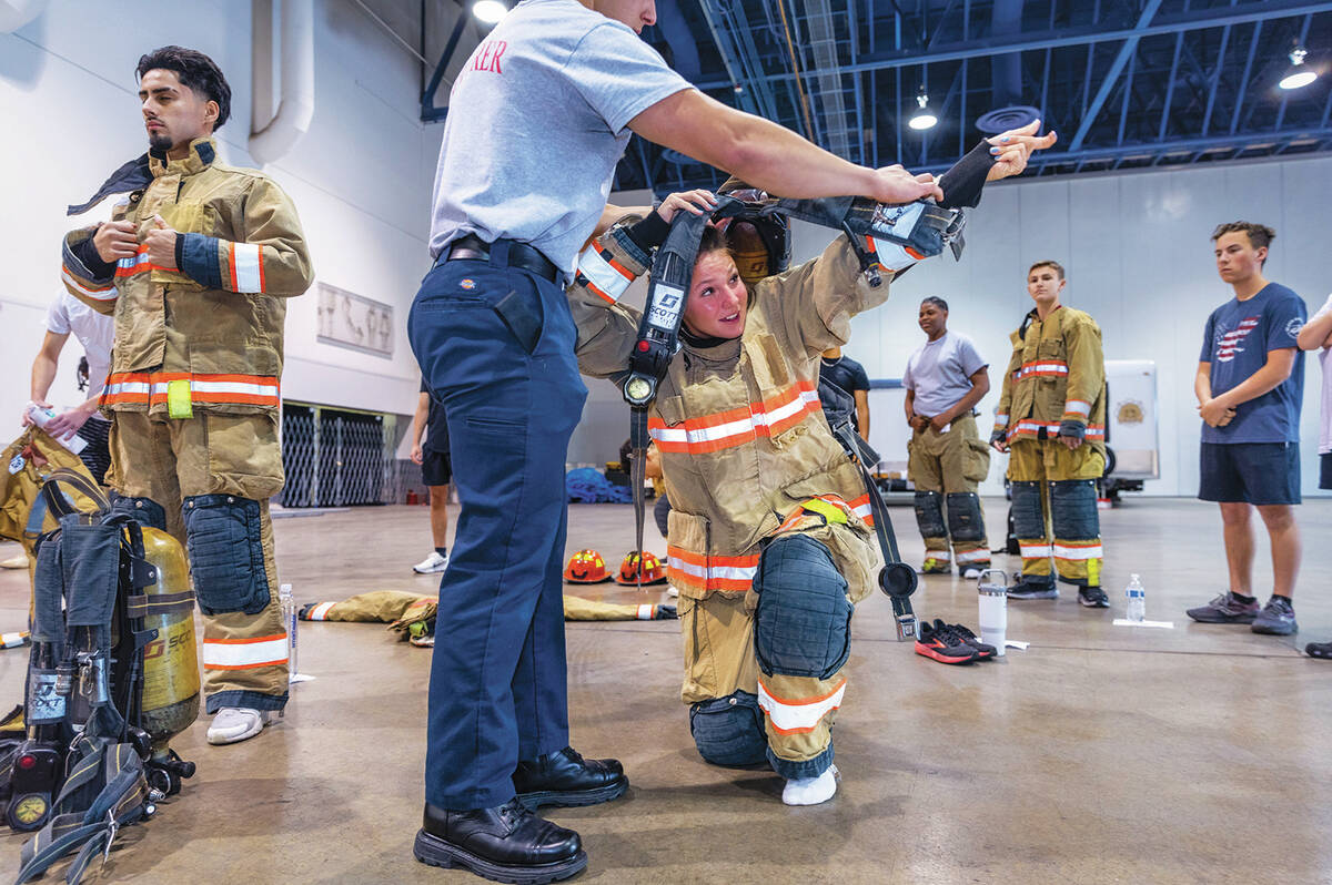 Participant Kailey Daforno, 15, is assisted by an explorer while putting on an oxygen tank duri ...