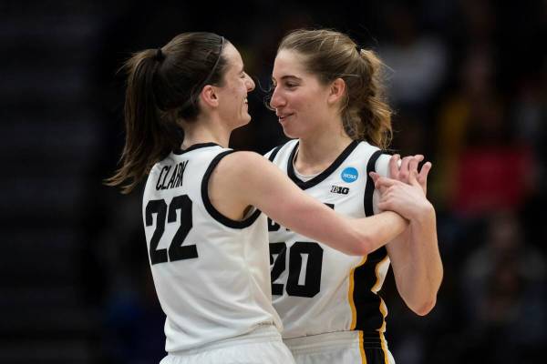 Iowa guards Caitlin Clark (22) and Kate Martin hug during the second half of an Elite 8 college ...