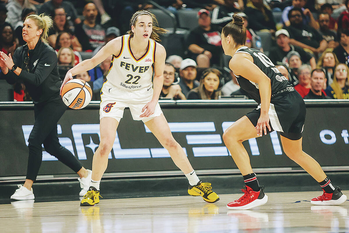 Indiana Fever guard Caitlin Clark (22) dribbles the ball as Aces guard Kelsey Plum (10) guards ...