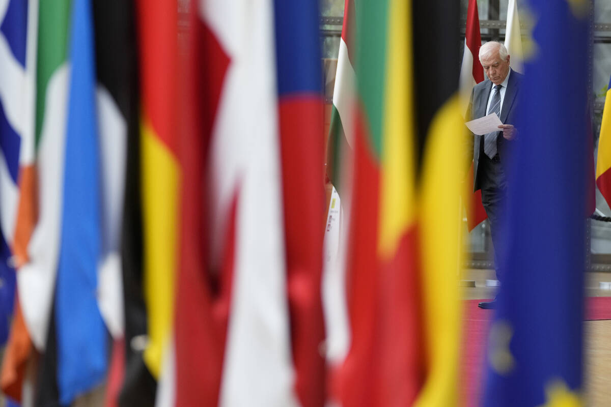 European Union foreign policy chief Josep Borrell, right, reads over his papers as he arrives f ...