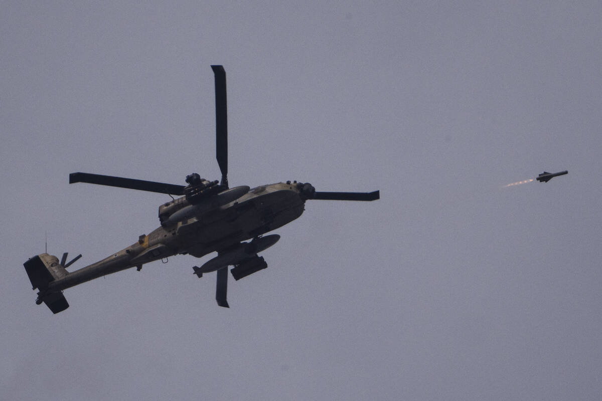 An Israeli Apache helicopter fires a missile towards the Gaza Strip, as seen from southern Isra ...