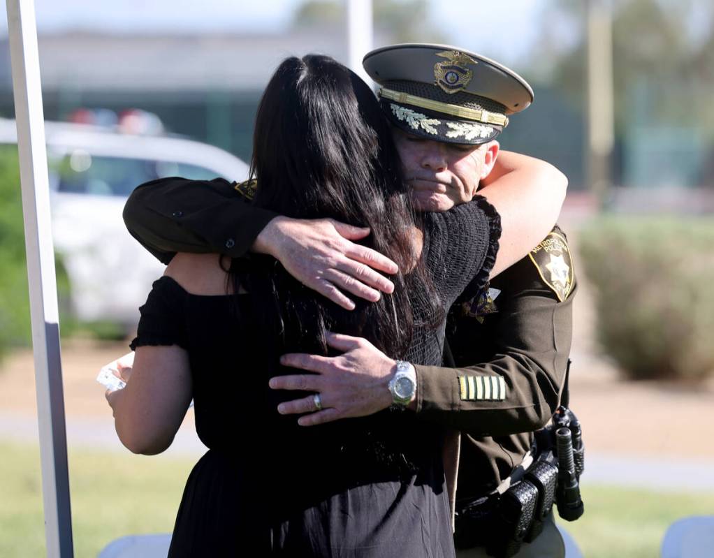 Kylee Prendes, daughter of fallen Las Vegas police Sgt. Henry Prendes, right, gets a hug from C ...