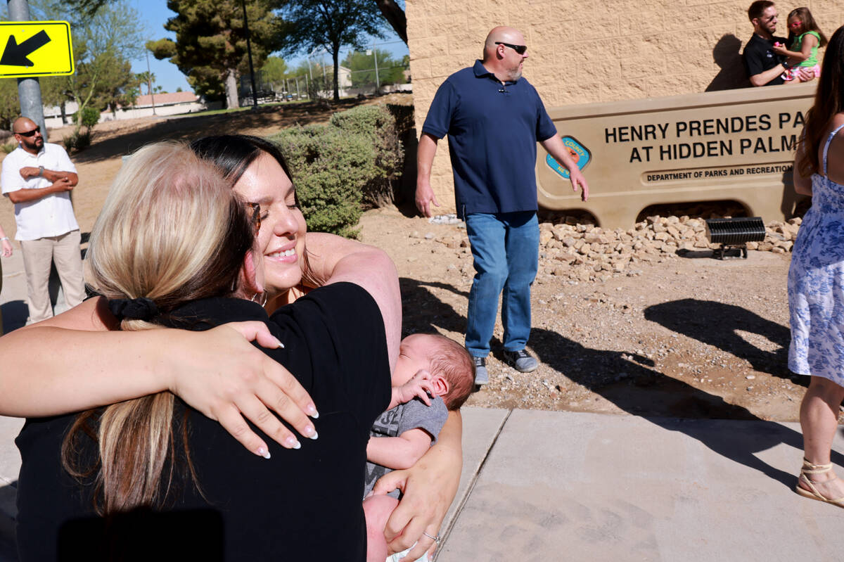 Kylee Prendes, daughter of fallen Las Vegas police Sgt. Henry Prendes, right, gets a hug from f ...