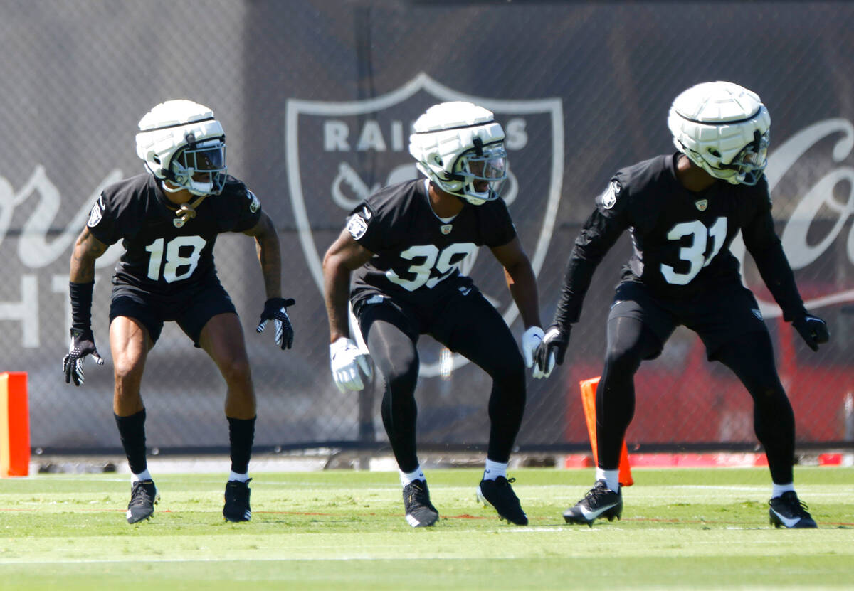 Raiders cornerbacks Jack Jones (18) Nate Hobbs (39) and Brandon Facyson (31) run through drills ...