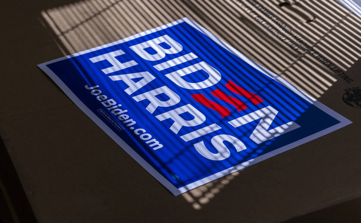 A Biden-Harris sign catches the window light atop a box of many more during a press conference ...