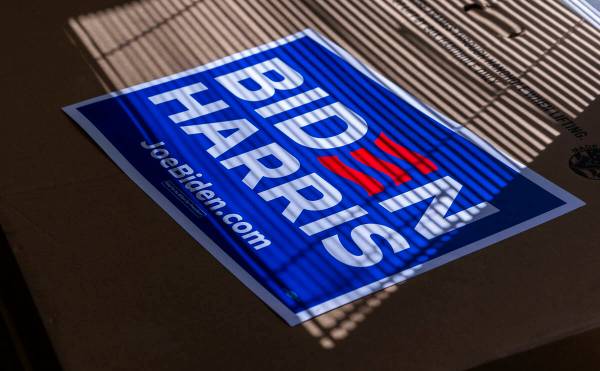 A Biden-Harris sign catches the window light atop a box of many more during a press conference ...