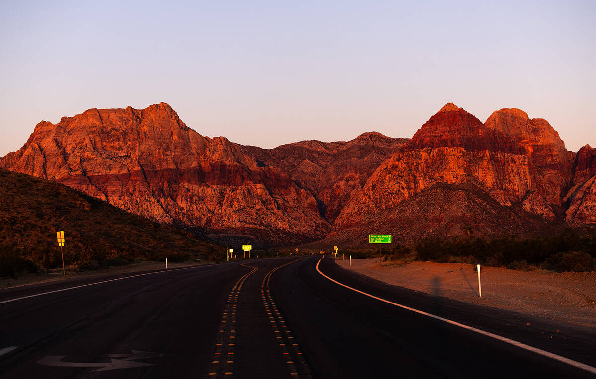 The rising sun illuminates the towering red sandstone peaks in Red Rock Canyon National Conserv ...