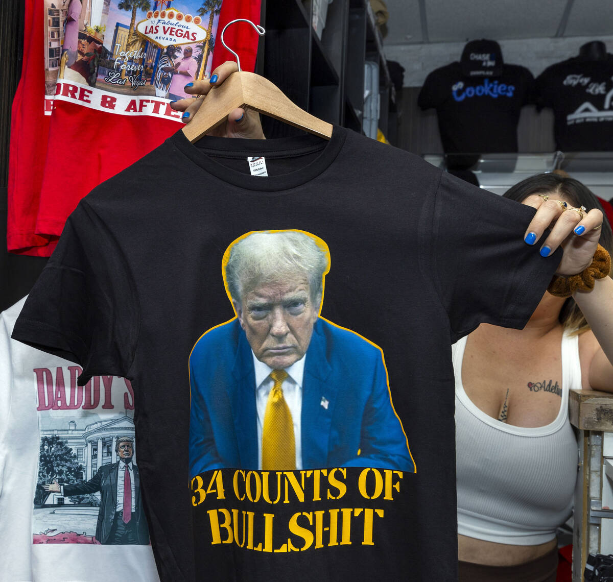 A vendor holds up a new t-shirt related to former President Donald Trump being convicted on 34 ...