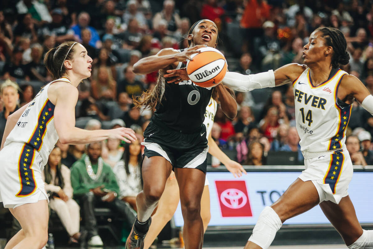 Aces guard Jackie Young (0) fights to keep the ball in her possession during a game between the ...