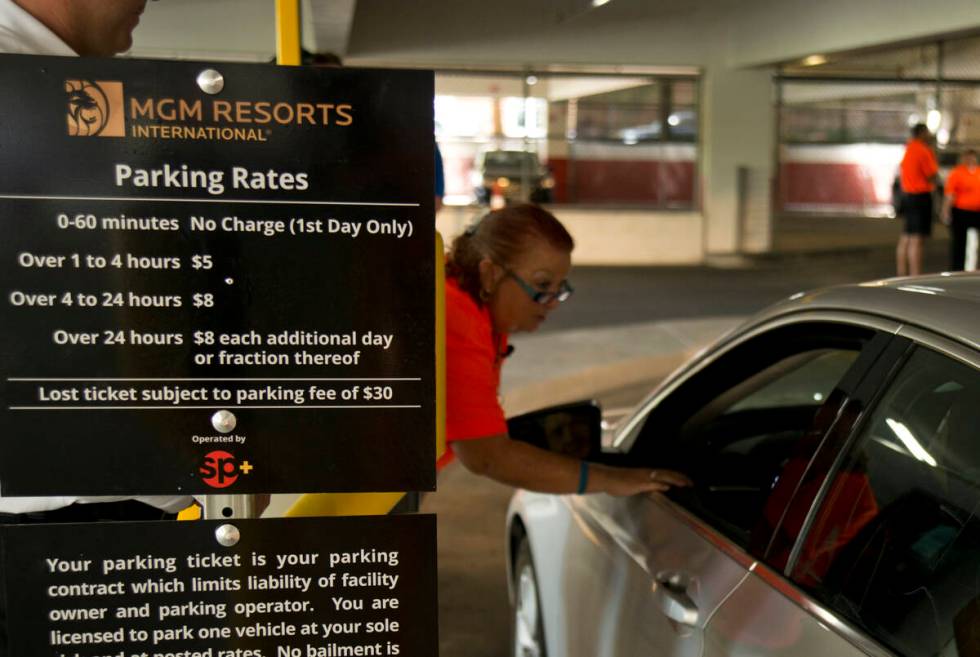 Viv Fasulo helps a customer enter the parking garage on the first day of paid parking at the Mo ...