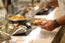 A customer gets food at the Feast Buffet at the Station Casino hotel-casino in Las Vegas, Wedne ...