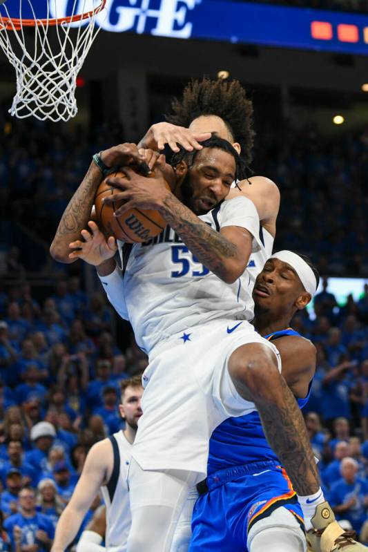 Dallas Mavericks forward Derrick Jones Jr., foreground, and teammate Dereck Lively II, top, cha ...