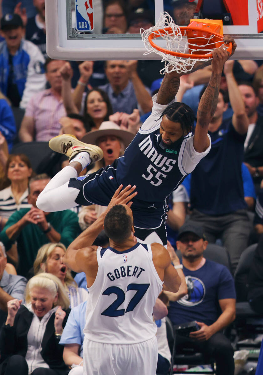 Dallas Mavericks forward Derrick Jones Jr. (55) scores over Minnesota Timberwolves center Rudy ...