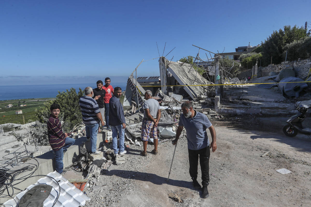 Lebanese men inspect a destroyed house that was hit on Friday night by an Israeli airstrike, ki ...