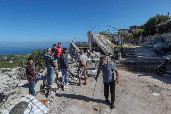 Lebanese men inspect a destroyed house that was hit on Friday night by an Israeli airstrike, ki ...