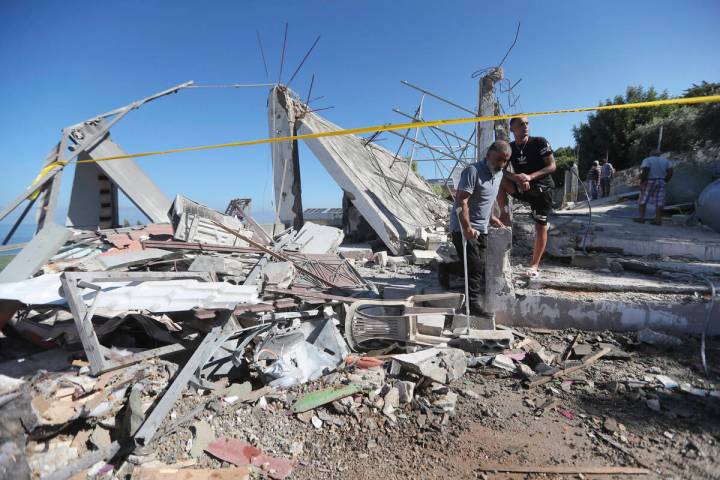 Lebanese men inspect a destroyed house that was hit on Friday night by an Israeli airstrike, ki ...