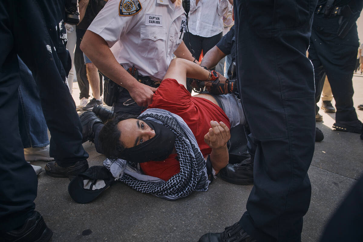 New York City police officers detain a pro-Palestinian demonstrator during a protest demanding ...