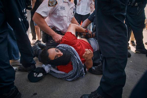 New York City police officers detain a pro-Palestinian demonstrator during a protest demanding ...