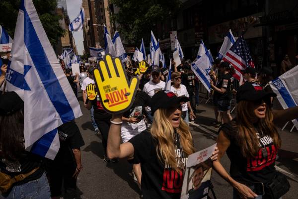 People hold Israeli flags and signs ahead of the annual Israel Day Parade on Sunday, June 2, 20 ...