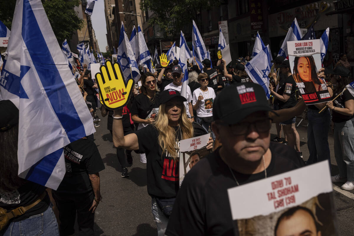 People hold signs and Israeli flags ahead of the annual Israel Day Parade on Sunday, June 2, 20 ...