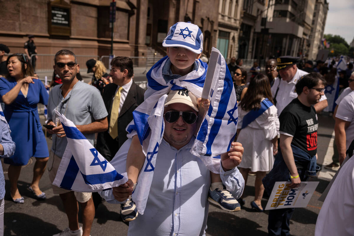 People holding Israeli flags gather ahead of the annual Israel Day Parade on Fifth Avenue on Su ...
