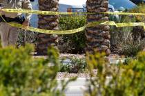 A police officer put up crime scene tape where Las Vegas police investigate a shooting at City ...